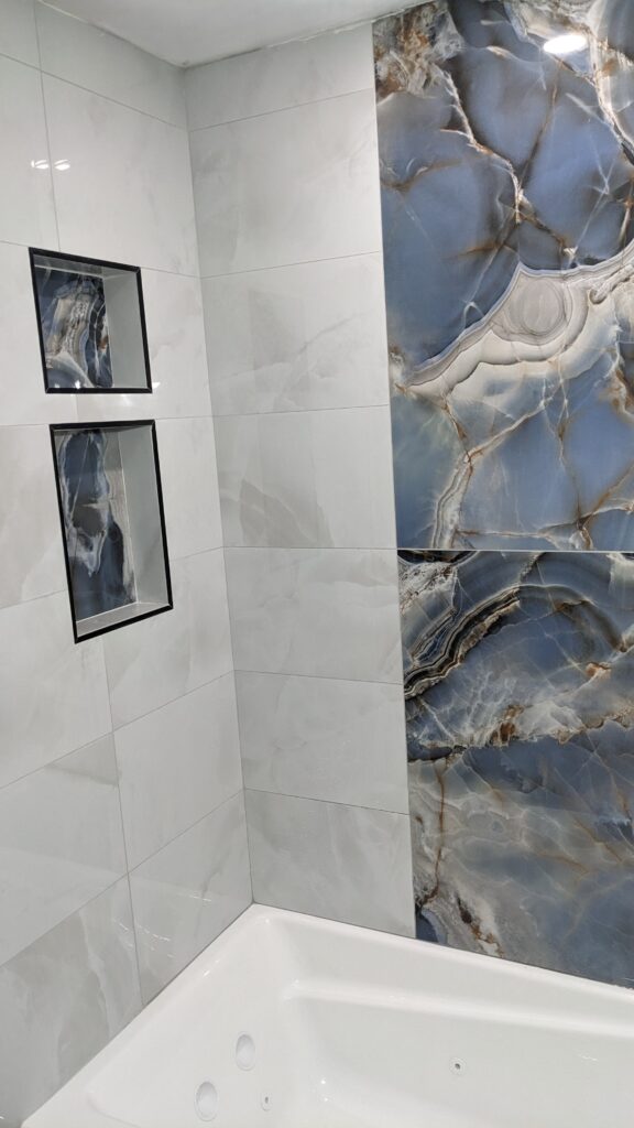 Bathroom with blue marble accent wall tiles.
