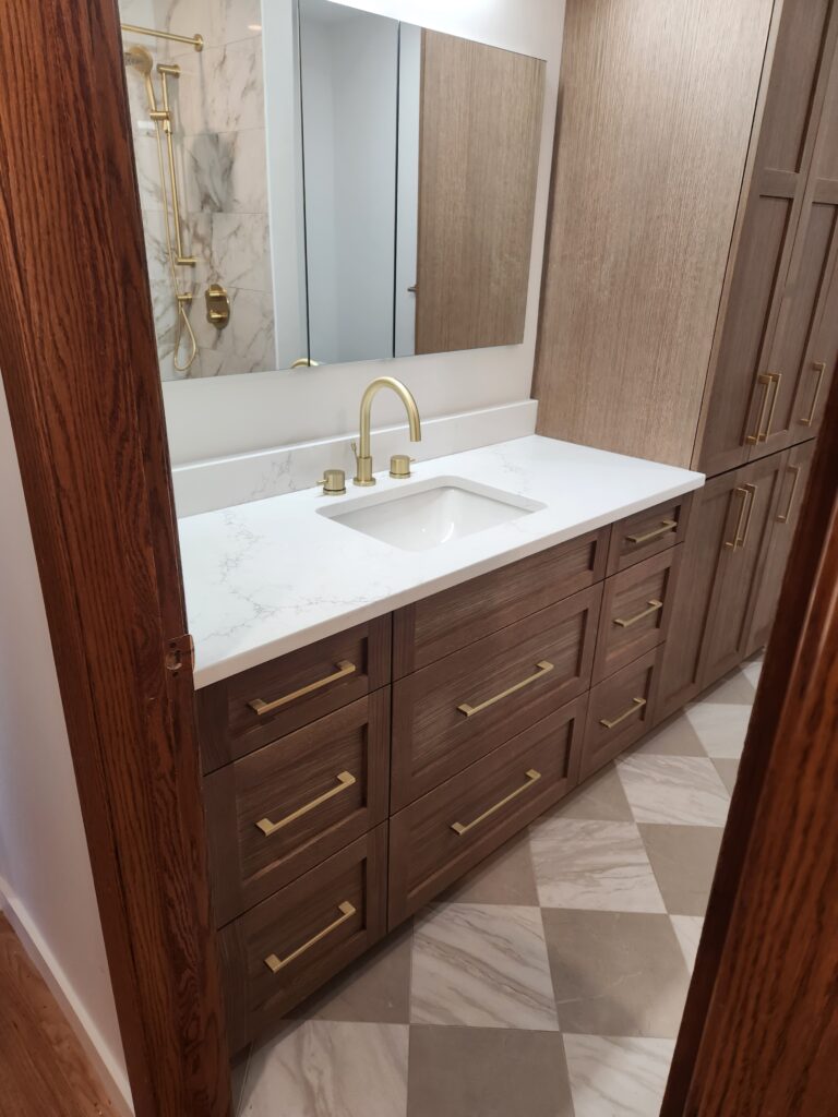 Elegant bathroom vanity with marble countertop and brass fixtures.