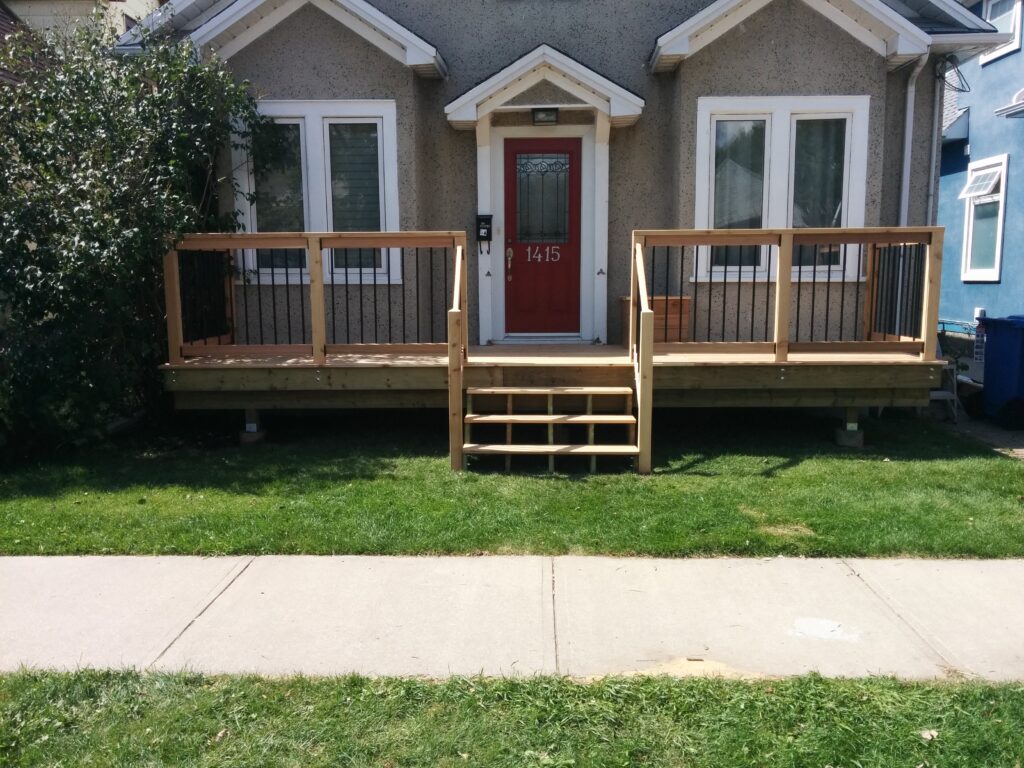 Small gray house with a wooden porch and stairs.
