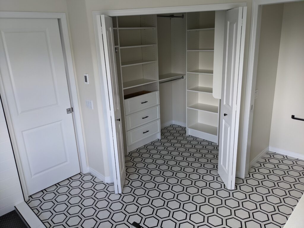 White closet with hexagonal tiled floor.