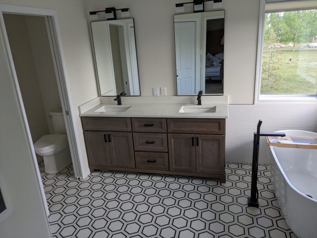 Modern bathroom with double vanity and bathtub.