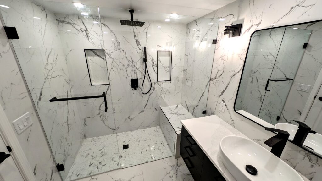Modern bathroom with marble walls and walk-in shower.
