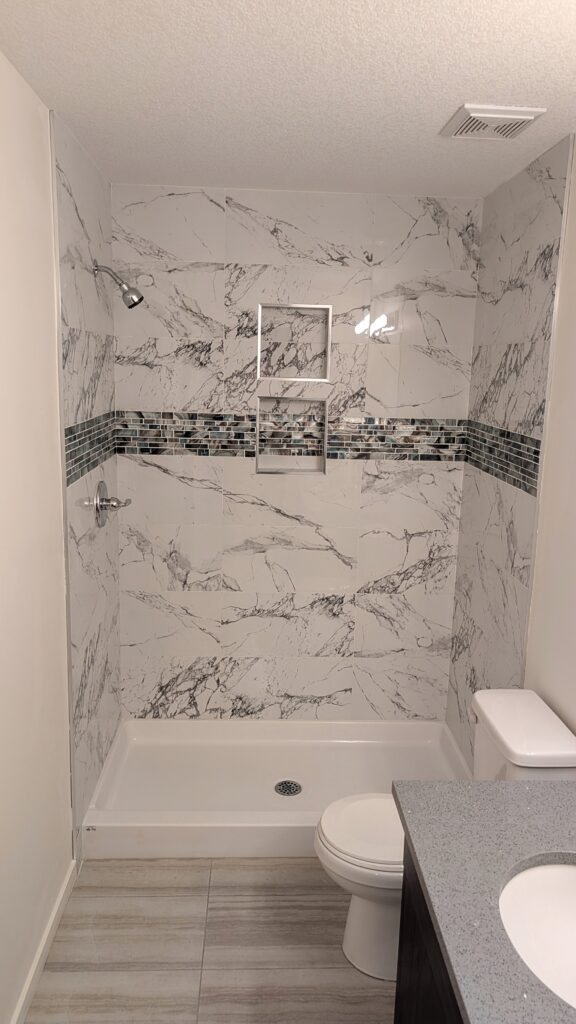 Modern bathroom with marble tiles and shower.