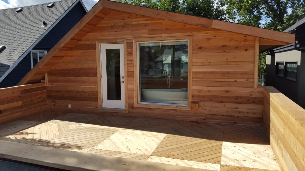 A small wooden cabin with large window and white door.